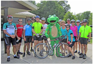 group of cyclists with giant frog