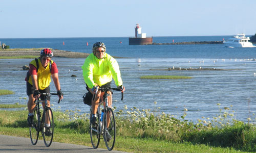 Cyclists riding by ocean