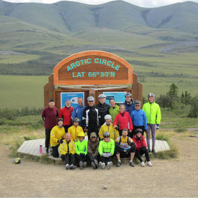 Group of Cyclists at Arctic Circle
